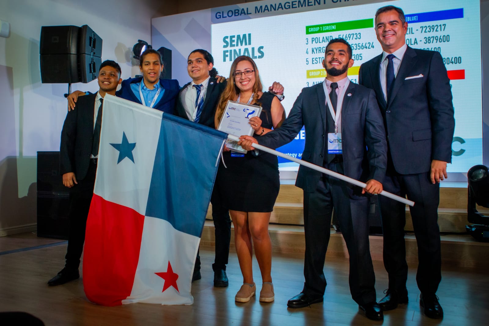 Equipo panameño del GMC 2021 en el escenario de las semifinales, sosteniendo la bandera de Panamá y el certificado de participación